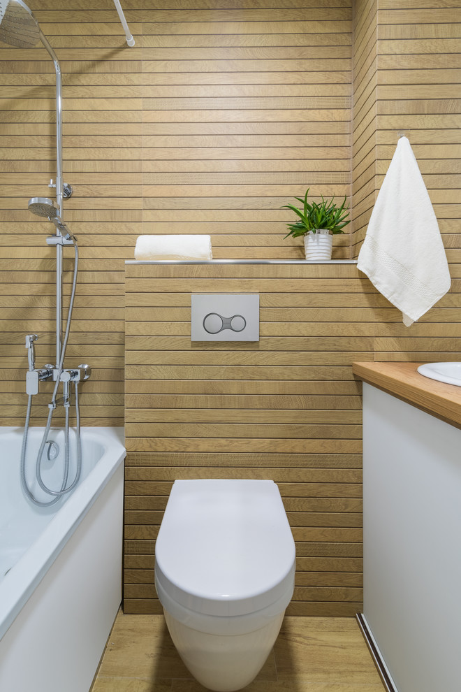 Idéer för funkis brunt en-suite badrum, med släta luckor, vita skåp, ett badkar i en alkov, en dusch/badkar-kombination, en toalettstol med separat cisternkåpa, brun kakel, ett nedsänkt handfat och brunt golv
