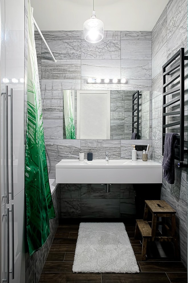 Imagen de cuarto de baño principal actual pequeño con armarios con paneles lisos, puertas de armario blancas, combinación de ducha y bañera, baldosas y/o azulejos grises, lavabo integrado, ducha con cortina y encimeras blancas