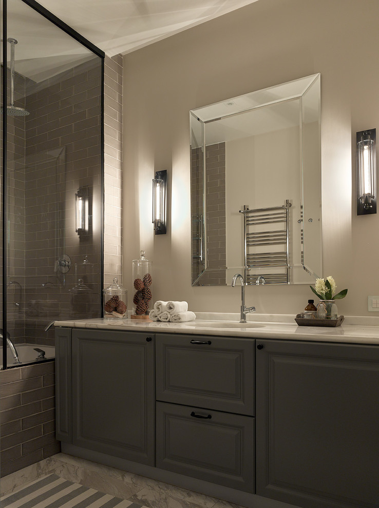 Immagine di una stanza da bagno padronale classica con ante grigie, vasca ad alcova, piastrelle grigie, pareti grigie e lavabo sottopiano