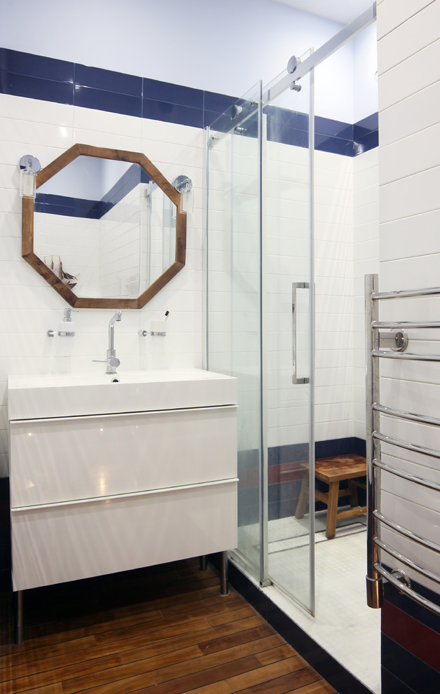 Пример оригинального дизайна: маленькая ванная комната в скандинавском стиле с плоскими фасадами, белыми фасадами, душем в нише, белой плиткой, керамической плиткой, белыми стенами, паркетным полом среднего тона, душевой кабиной, накладной раковиной и душем с раздвижными дверями для на участке и в саду
