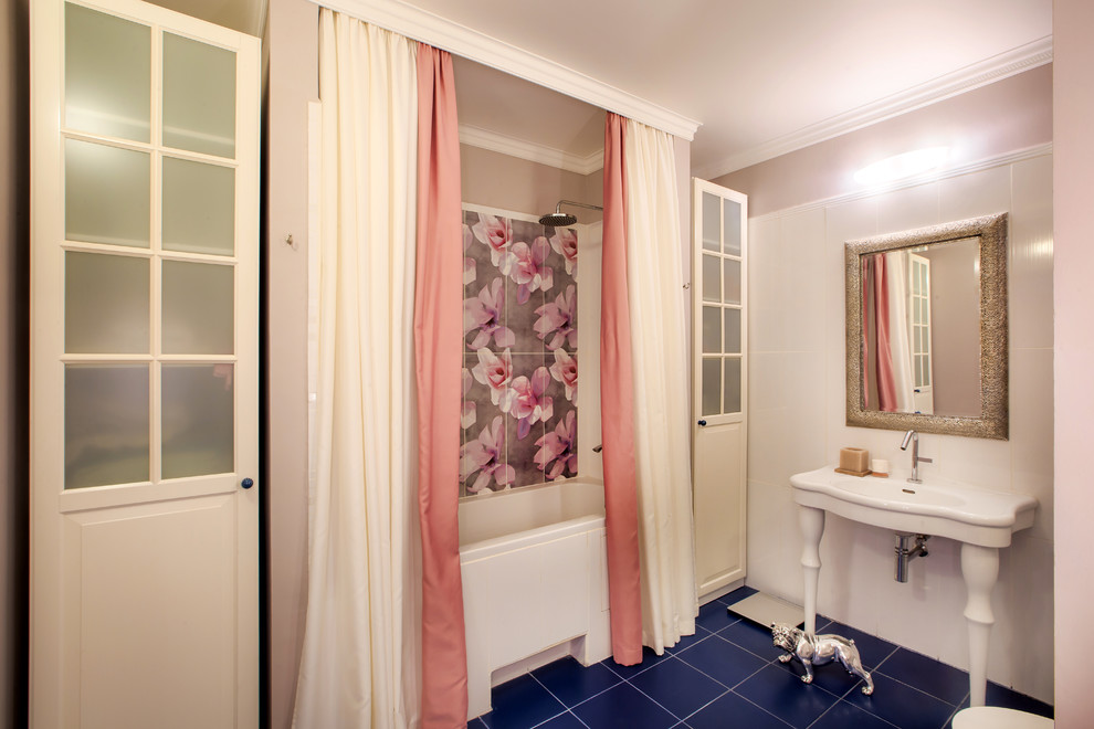 На фото: большая главная ванная комната в стиле неоклассика (современная классика) с белыми фасадами, ванной в нише, унитазом-моноблоком, белой плиткой, керамогранитной плиткой, розовыми стенами, полом из керамической плитки, синим полом и консольной раковиной