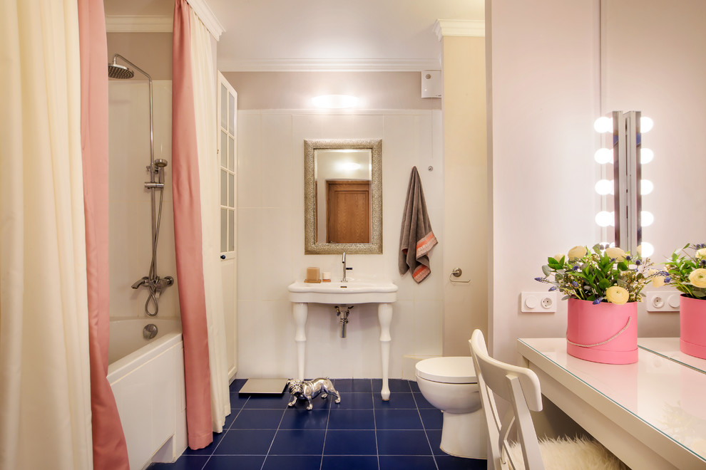 На фото: большая главная ванная комната в стиле неоклассика (современная классика) с белыми фасадами, ванной в нише, белой плиткой, керамогранитной плиткой, розовыми стенами, полом из керамической плитки, синим полом, консольной раковиной и унитазом-моноблоком