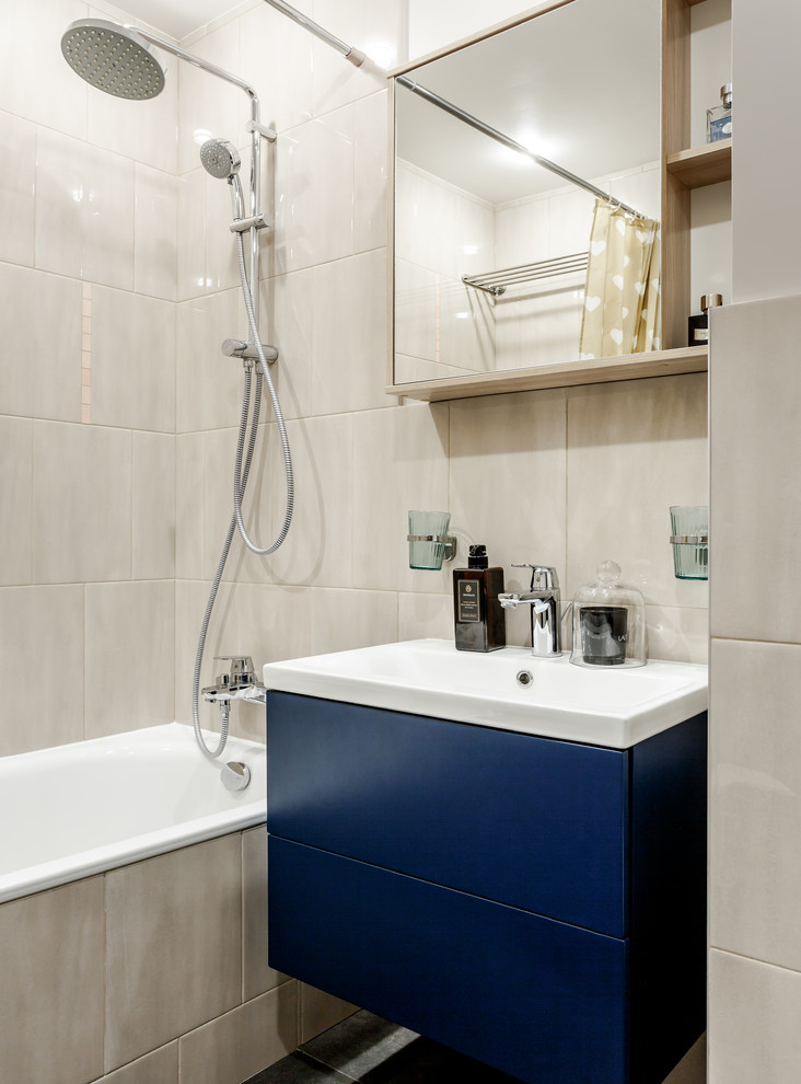 Inspiration pour une salle de bain principale design avec un placard à porte plane, des portes de placard bleues, une baignoire en alcôve, un combiné douche/baignoire, un carrelage gris, un lavabo intégré et une cabine de douche avec un rideau.