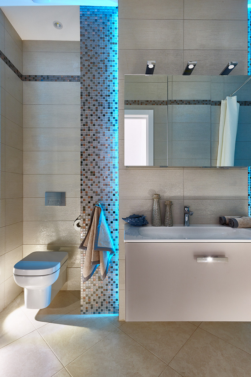 Modelo de cuarto de baño contemporáneo con armarios con paneles lisos, puertas de armario beige, sanitario de pared, baldosas y/o azulejos beige, aseo y ducha y lavabo integrado