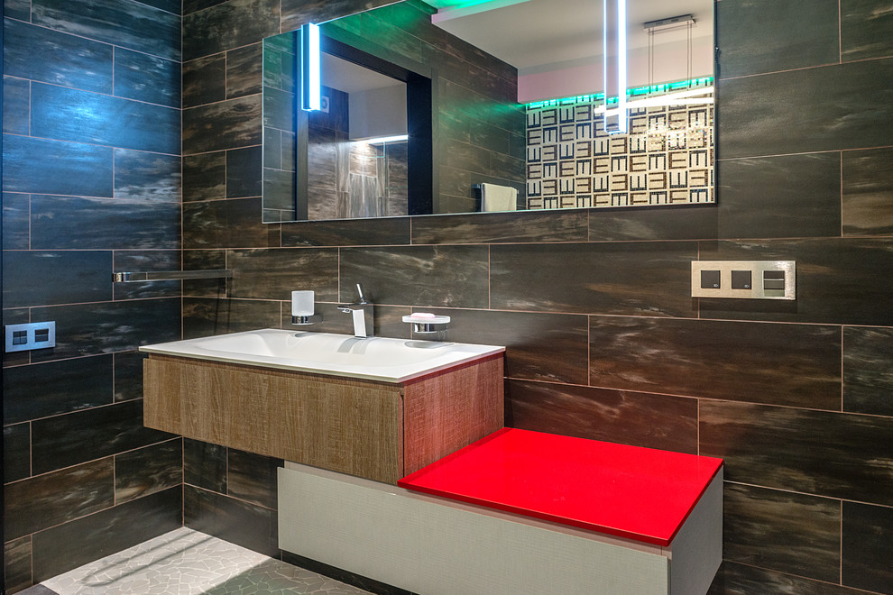 Foto di una stanza da bagno contemporanea con piastrelle nere e lavabo integrato