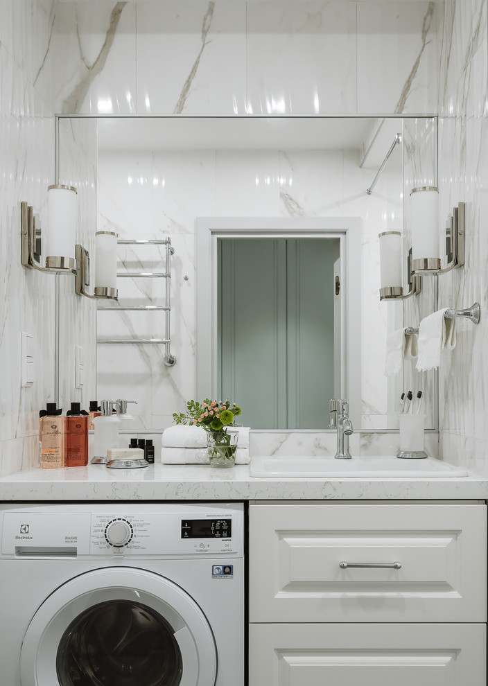 Пример оригинального дизайна: главная ванная комната среднего размера в стиле неоклассика (современная классика) с фасадами с выступающей филенкой, белыми фасадами, душем в нише, инсталляцией, белой плиткой, керамогранитной плиткой, белыми стенами, полом из керамогранита, врезной раковиной, столешницей из искусственного кварца, серым полом, шторкой для ванной, белой столешницей и гигиеническим душем
