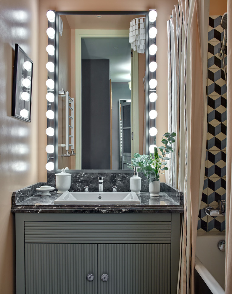 Imagen de cuarto de baño principal clásico renovado con puertas de armario grises, bañera empotrada, combinación de ducha y bañera, paredes beige, lavabo encastrado y ducha con cortina
