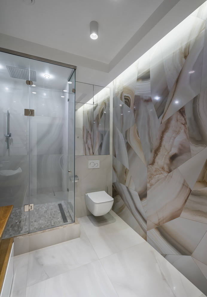 Bild på ett funkis badrum med dusch, med en hörndusch, en vägghängd toalettstol, beige kakel, vitt golv och dusch med gångjärnsdörr