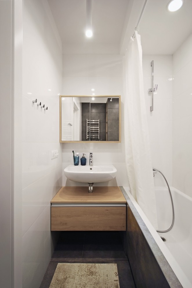 Exemple d'une salle de bain principale tendance de taille moyenne avec une baignoire encastrée, WC suspendus, un carrelage blanc, des carreaux de porcelaine, un lavabo suspendu et un plan de toilette en stratifié.