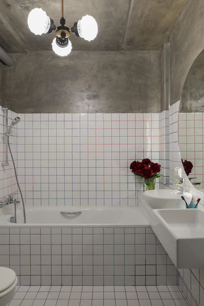 Idée de décoration pour une salle de bain principale design avec une baignoire en alcôve, un combiné douche/baignoire, un carrelage blanc, un mur gris, une vasque et un sol blanc.