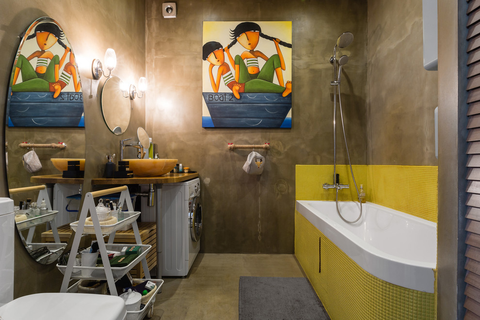 На фото: ванная комната в современном стиле с ванной в нише, душем над ванной, раздельным унитазом, желтой плиткой, коричневыми стенами и настольной раковиной