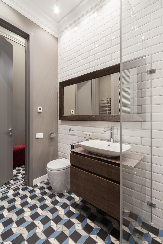Immagine di una stanza da bagno classica di medie dimensioni con doccia alcova, WC a due pezzi, piastrelle in ceramica, lavabo a bacinella, porta doccia a battente, ante in legno scuro e piastrelle bianche