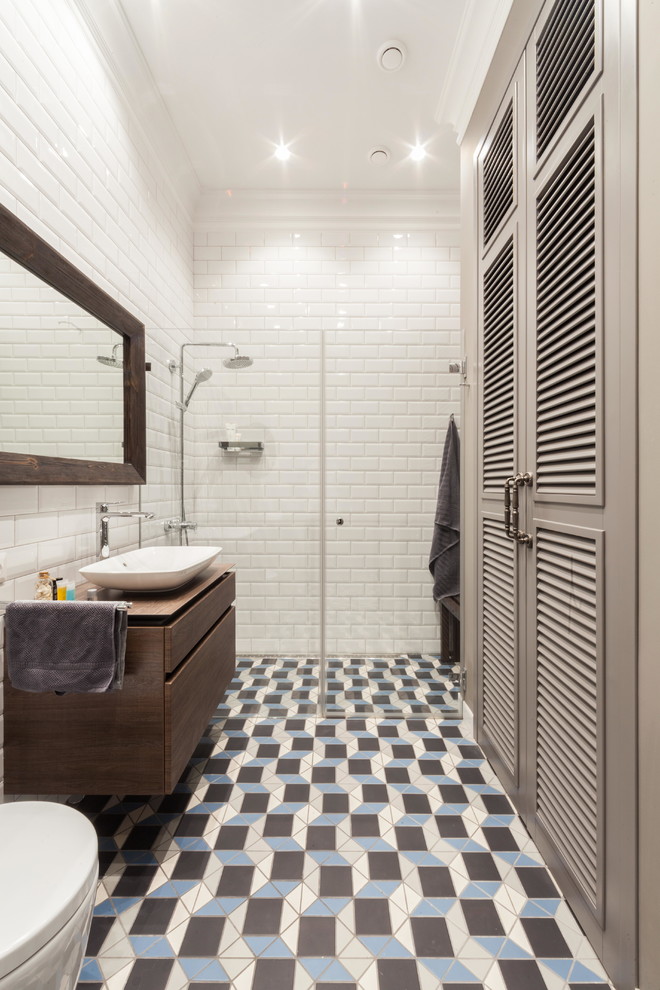 Idéer för att renovera ett vintage badrum med dusch, med släta luckor, skåp i mellenmörkt trä, en kantlös dusch, vit kakel, tunnelbanekakel, klinkergolv i porslin, ett fristående handfat, flerfärgat golv och dusch med gångjärnsdörr