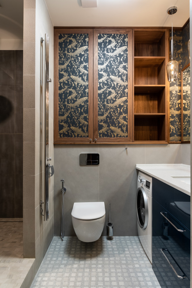 На фото: ванная комната со стиральной машиной в современном стиле с плоскими фасадами, инсталляцией, душевой кабиной, врезной раковиной, белой столешницей, тумбой под одну раковину, напольной тумбой и обоями на стенах