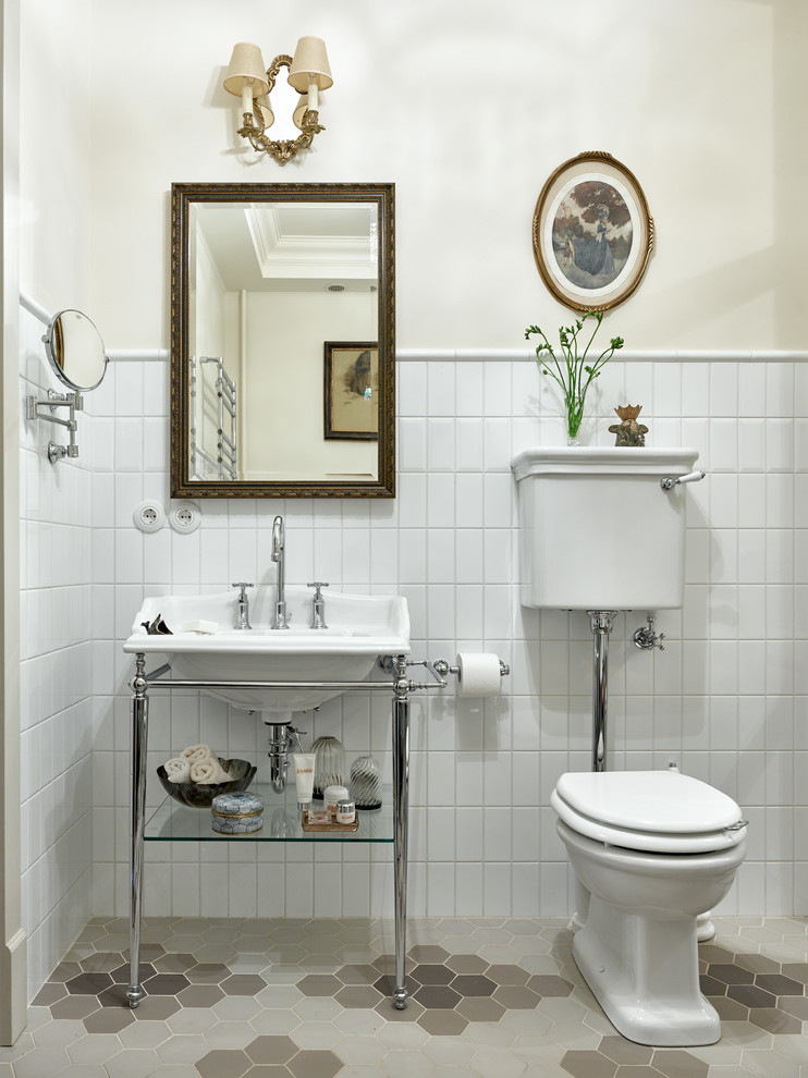 На фото: ванная комната в стиле неоклассика (современная классика) с раздельным унитазом, белой плиткой, керамической плиткой, белыми стенами и консольной раковиной с