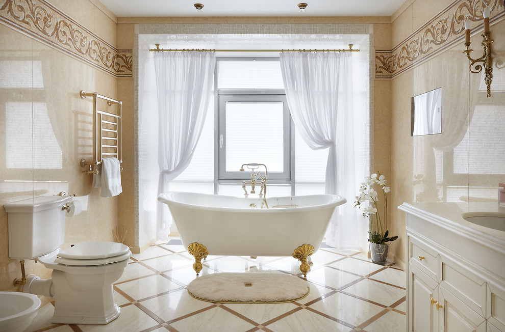 Bild på ett vintage en-suite badrum, med luckor med infälld panel, vita skåp, ett badkar med tassar, en toalettstol med separat cisternkåpa, beige kakel och ett undermonterad handfat