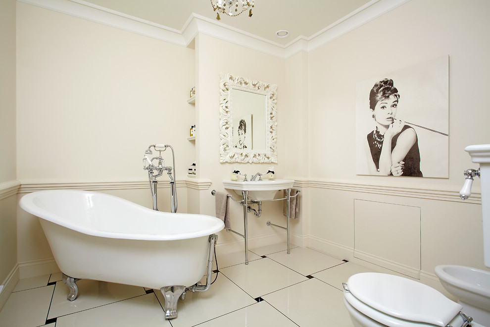 Esempio di una stanza da bagno padronale classica con vasca con piedi a zampa di leone, piastrelle bianche, pareti bianche, lavabo a consolle e bidè