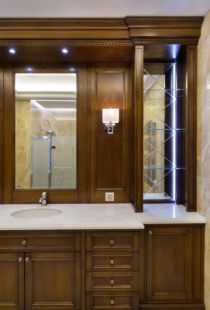На фото: ванная комната среднего размера в классическом стиле с фасадами с утопленной филенкой, фасадами цвета дерева среднего тона, бежевой плиткой и врезной раковиной