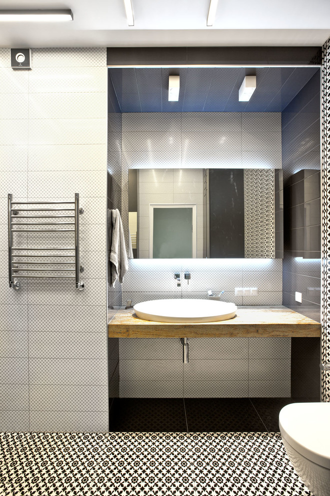 Immagine di una stanza da bagno minimal con pavimento multicolore, piastrelle bianche, pistrelle in bianco e nero e lavabo da incasso