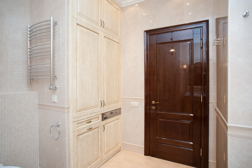 Cette image montre une salle de bain principale traditionnelle en bois clair de taille moyenne avec un placard avec porte à panneau surélevé, WC suspendus, un carrelage beige, des carreaux de porcelaine, un mur beige et un sol en carrelage de porcelaine.
