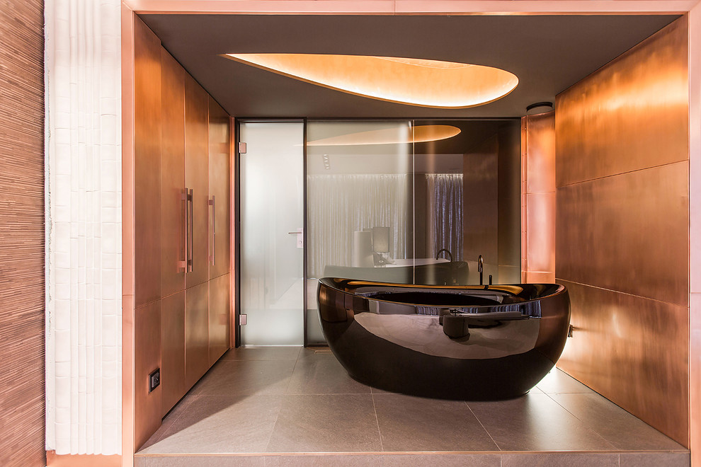 Пример оригинального дизайна: ванная комната в современном стиле с отдельно стоящей ванной и оранжевыми стенами