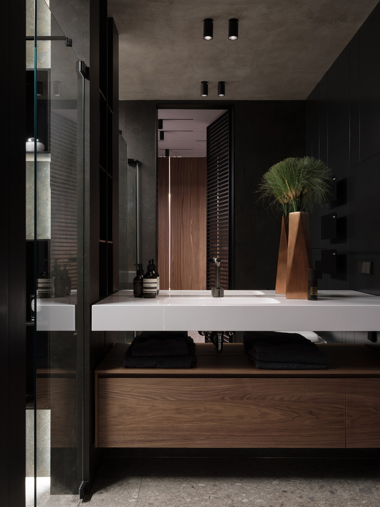 Пример оригинального дизайна: ванная комната в современном стиле с плоскими фасадами, монолитной раковиной, серым полом, белой столешницей и темными деревянными фасадами