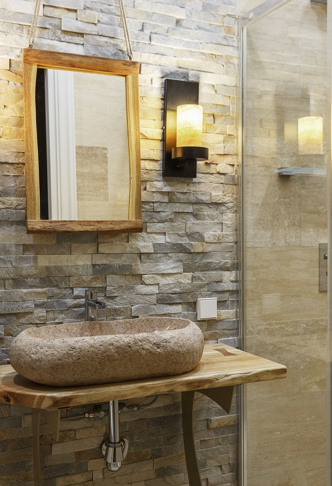 Modelo de cuarto de baño rústico pequeño con aseo y ducha, lavabo sobreencimera, encimera de madera, encimeras beige y piedra