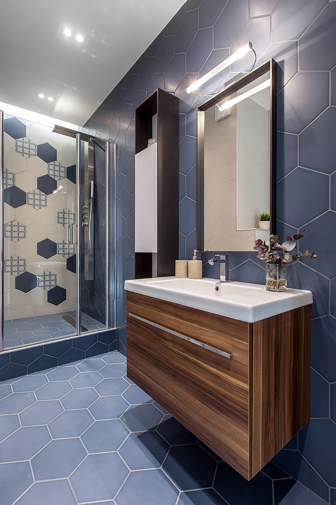 Inspiration för ett funkis badrum med dusch, med en vägghängd toalettstol, blått golv, släta luckor, skåp i mellenmörkt trä, en dusch i en alkov, blå kakel, flerfärgad kakel och ett integrerad handfat