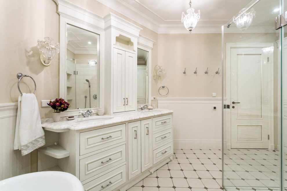 モスクワにあるトランジショナルスタイルのおしゃれな浴室 (レイズドパネル扉のキャビネット、白いキャビネット、ベージュの壁、アンダーカウンター洗面器、白い床、白い洗面カウンター) の写真