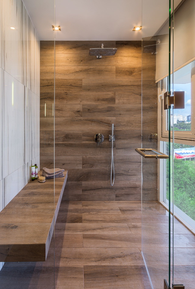На фото: ванная комната среднего размера в современном стиле с душем без бортиков, коричневой плиткой, душевой кабиной и душем с распашными дверями
