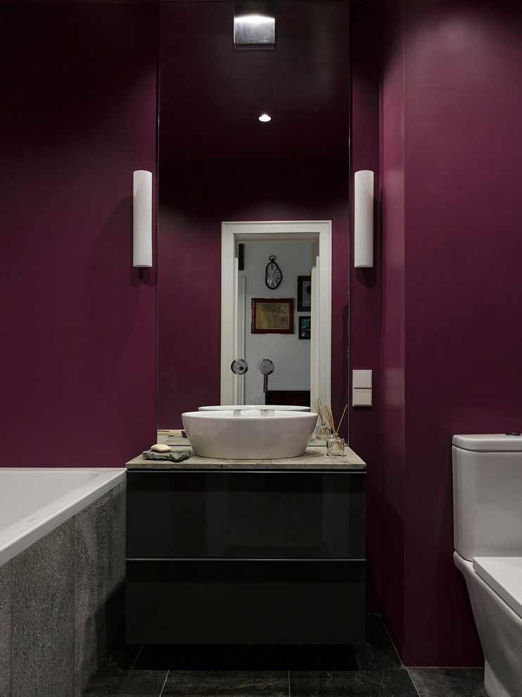 Imagen de cuarto de baño actual con bañera empotrada, sanitario de dos piezas, paredes púrpuras y lavabo sobreencimera