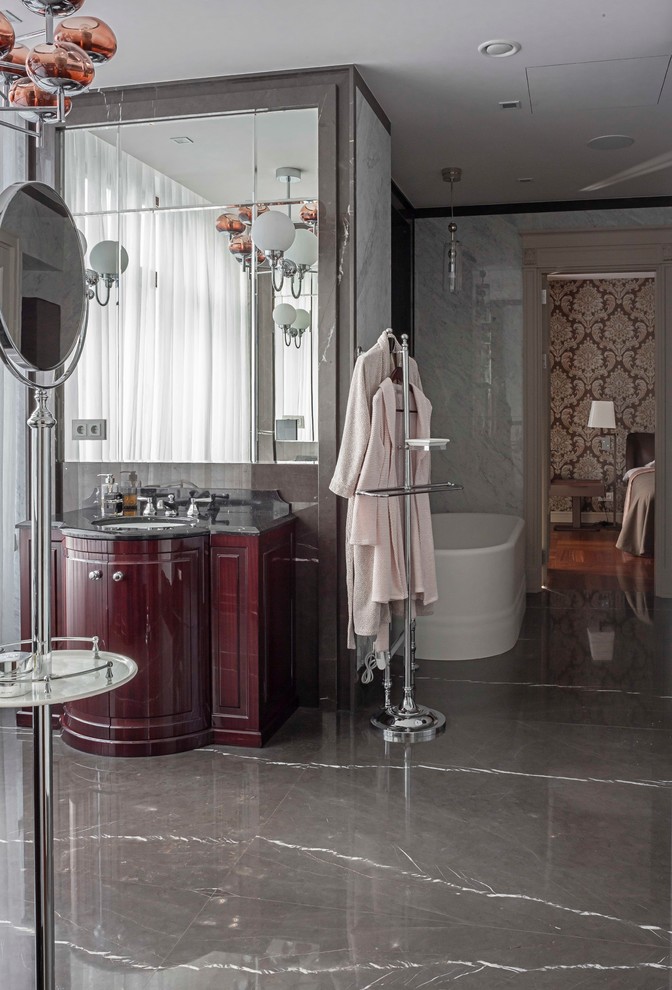 Стильный дизайн: главная ванная комната в классическом стиле с серой плиткой, врезной раковиной, отдельно стоящей ванной и мраморной столешницей - последний тренд