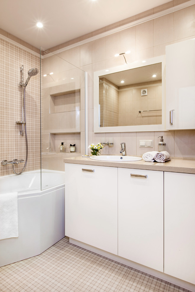 Idee per una stanza da bagno padronale design con ante lisce, ante bianche, vasca ad angolo, piastrelle beige, lavabo da incasso e pavimento beige