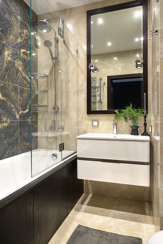 Exemple d'une salle de bain principale tendance avec un placard à porte plane, des portes de placard blanches, une baignoire en alcôve, un combiné douche/baignoire, un carrelage beige, un carrelage gris, un lavabo intégré et un sol beige.