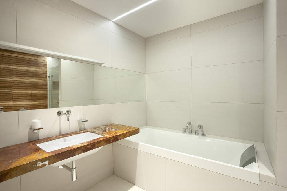 Идея дизайна: ванная комната среднего размера в современном стиле с ванной в нише, керамогранитной плиткой, полом из керамогранита, врезной раковиной, мраморной столешницей и серой плиткой