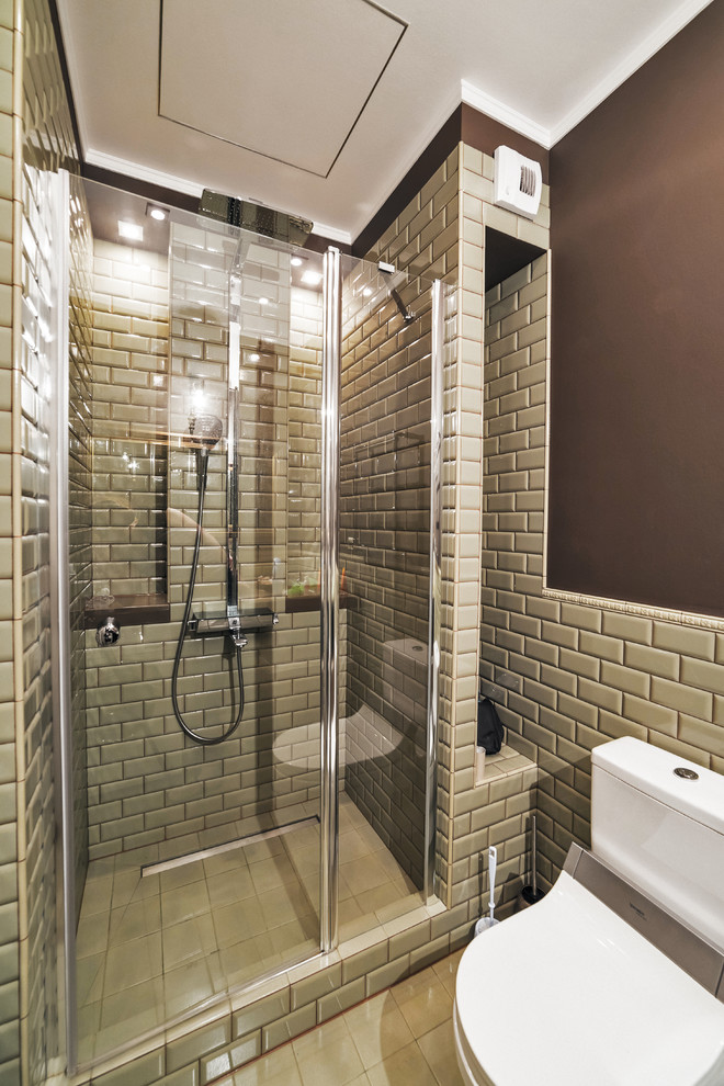 Cette image montre une salle de bain design avec un carrelage gris, un carrelage métro et une cabine de douche à porte battante.