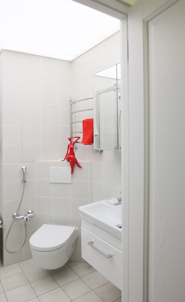 Immagine di una piccola stanza da bagno contemporanea con ante lisce, ante bianche, doccia ad angolo, WC sospeso, piastrelle grigie, piastrelle in ceramica, pavimento in gres porcellanato e lavabo sospeso