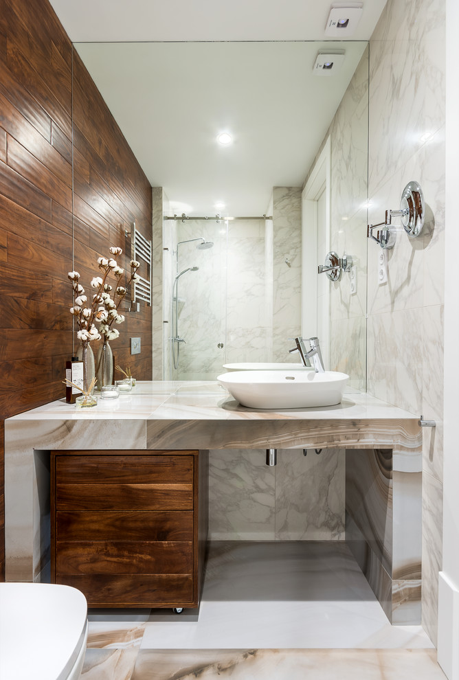 На фото: ванная комната в современном стиле с плоскими фасадами, темными деревянными фасадами, душем в нише, серой плиткой, белой плиткой, настольной раковиной, белым полом, душем с раздвижными дверями и белой столешницей с