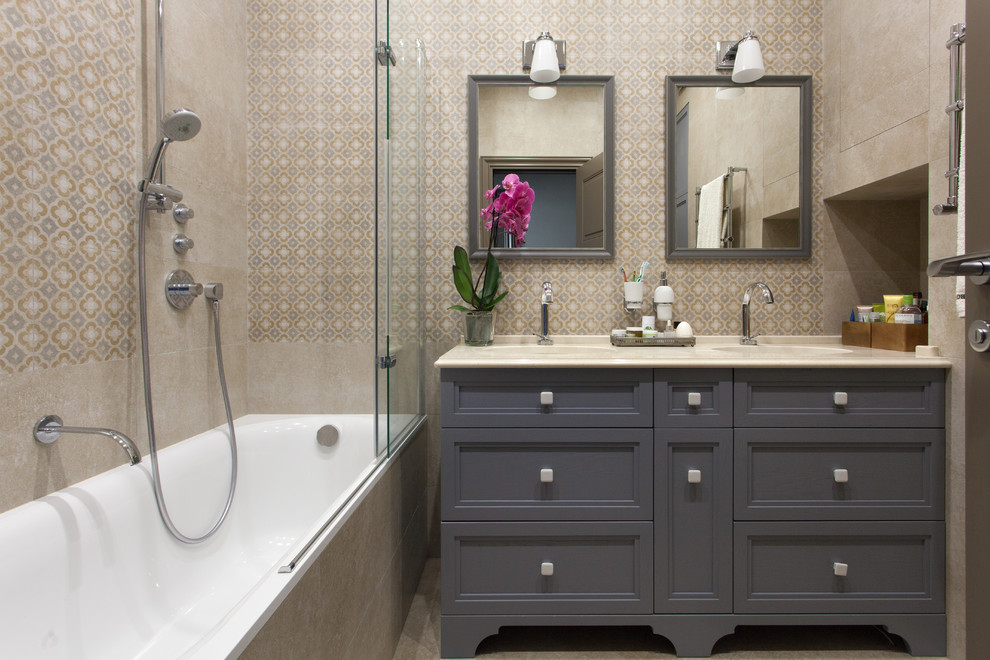 На фото: главная ванная комната в современном стиле с фасадами с утопленной филенкой, серыми фасадами, ванной в нише, бежевой плиткой, врезной раковиной, бежевым полом и бежевой столешницей с