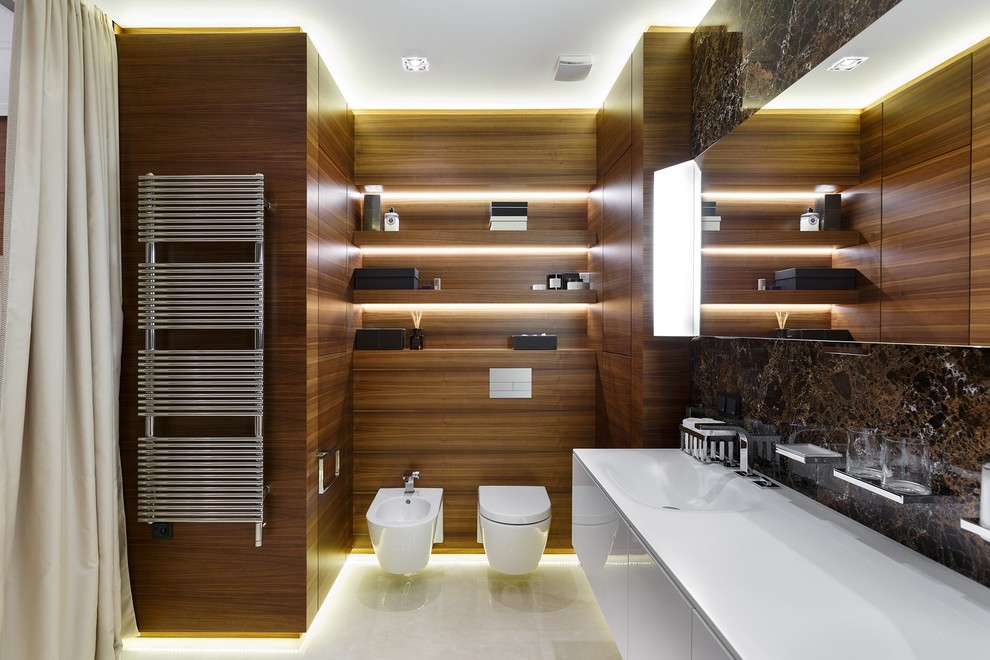 На фото: ванная комната в современном стиле с плоскими фасадами, белыми фасадами, биде, коричневой плиткой, коричневыми стенами и монолитной раковиной
