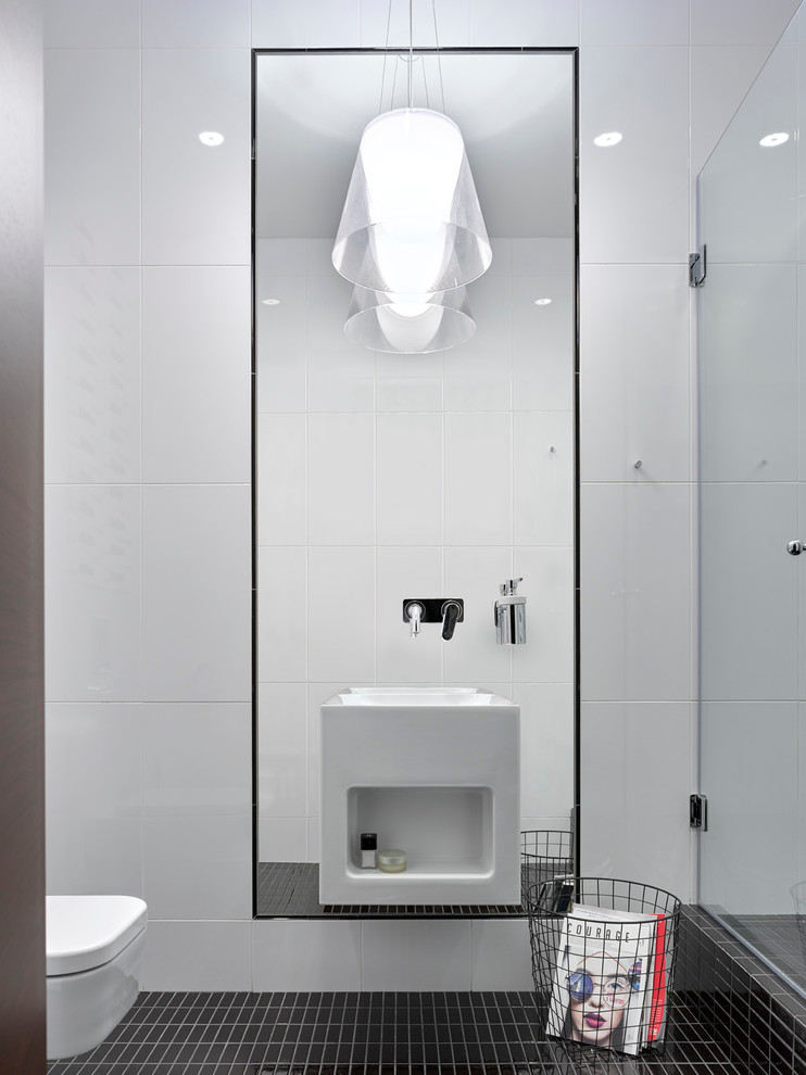 Immagine di una stanza da bagno con doccia minimal con WC sospeso, piastrelle bianche, piastrelle nere e lavabo sospeso