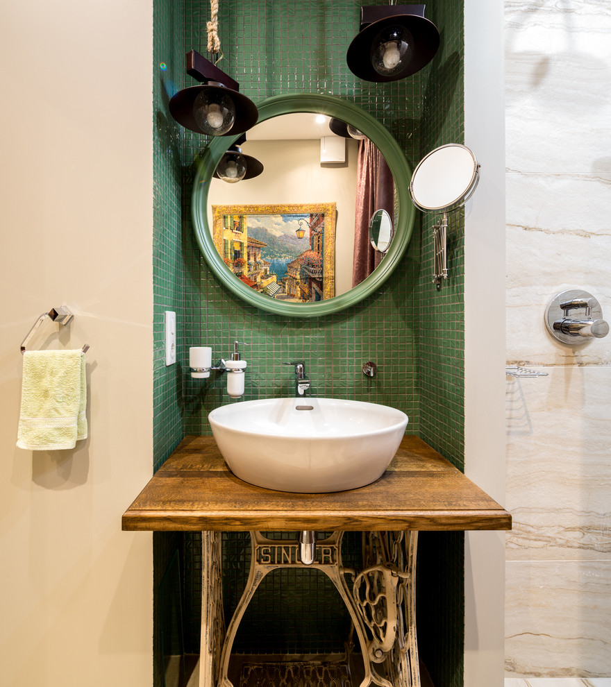 Réalisation d'une salle d'eau bohème avec un carrelage vert, mosaïque, un mur beige, une vasque, un plan de toilette en bois et un plan de toilette marron.
