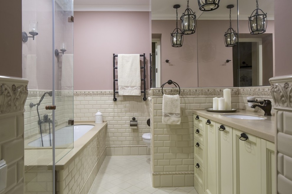 Идея дизайна: главный совмещенный санузел в классическом стиле с фасадами с утопленной филенкой, бежевыми фасадами, полновстраиваемой ванной, угловым душем, бежевой плиткой, плиткой кабанчик, инсталляцией, врезной раковиной, душем с распашными дверями, розовыми стенами и бежевым полом