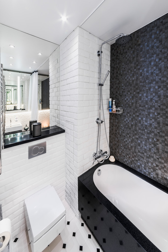 На фото: ванная комната в современном стиле с ванной в нише