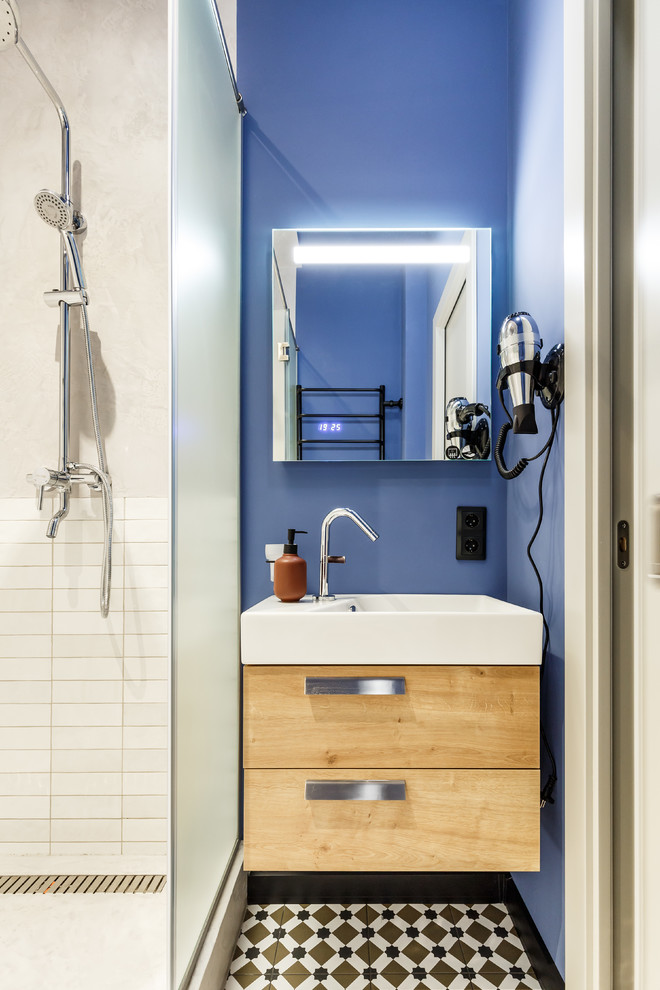 На фото: ванная комната в современном стиле с душем в нише, белой плиткой, керамической плиткой, светлыми деревянными фасадами, душевой кабиной и синими стенами