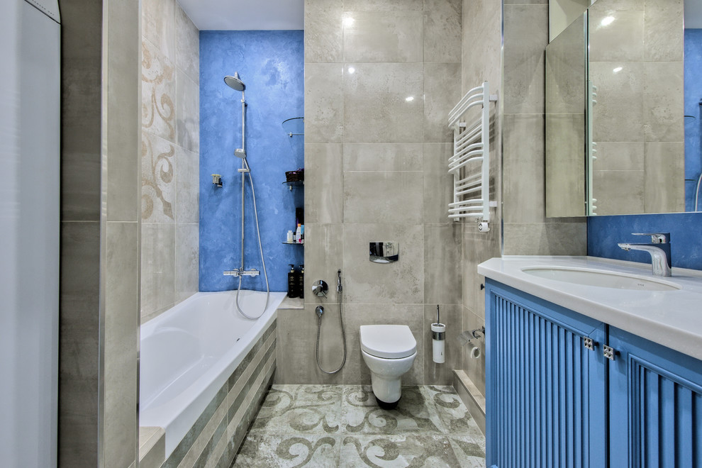 Источник вдохновения для домашнего уюта: главная ванная комната в современном стиле с фасадами с филенкой типа жалюзи, синими фасадами, ванной в нише, душем над ванной, серой плиткой, врезной раковиной, серым полом и белой столешницей