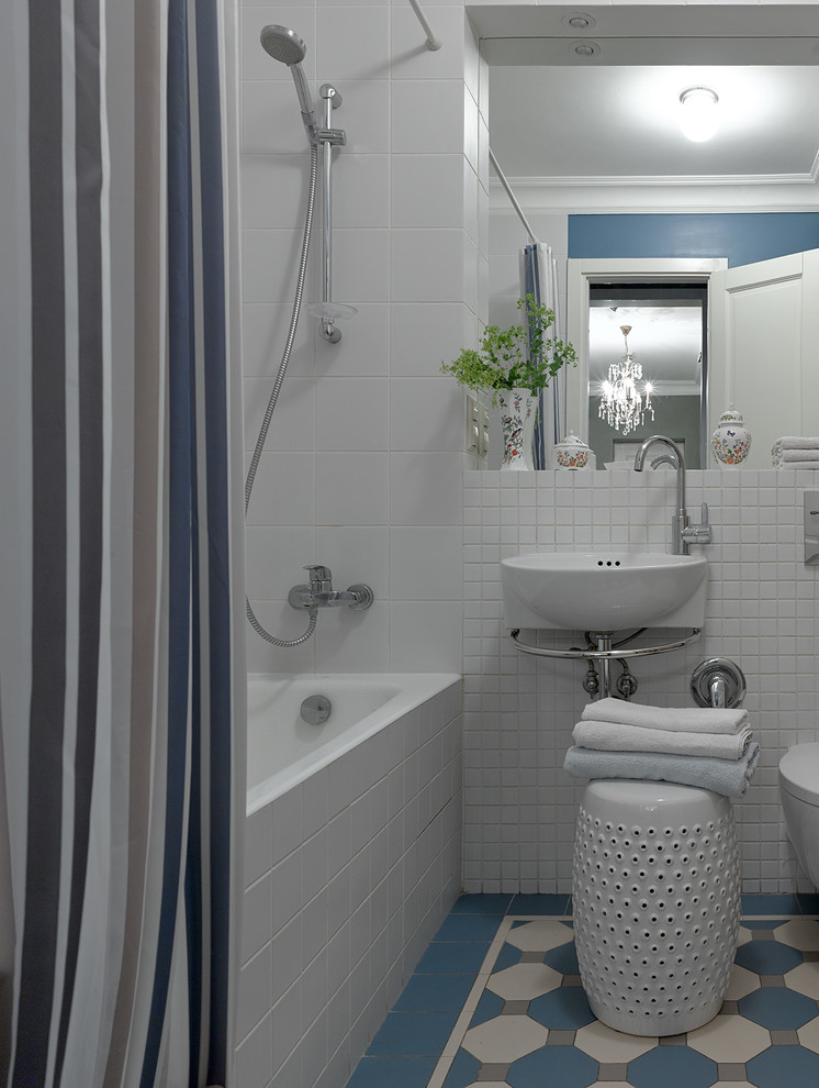 Modelo de cuarto de baño principal tradicional renovado pequeño con bañera empotrada, combinación de ducha y bañera, baldosas y/o azulejos azules, baldosas y/o azulejos blancos, lavabo suspendido, suelo azul y ducha con cortina