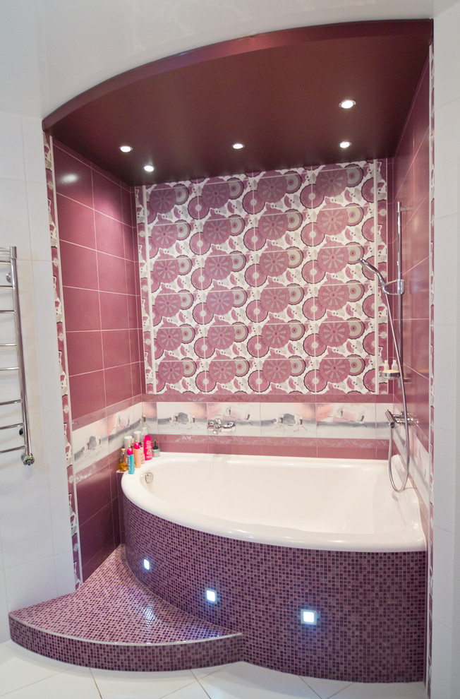 Medium sized contemporary ensuite bathroom in Moscow with flat-panel cabinets, white cabinets, a corner bath, a wall mounted toilet, multi-coloured tiles, ceramic tiles, multi-coloured walls, ceramic flooring, a built-in sink and solid surface worktops.