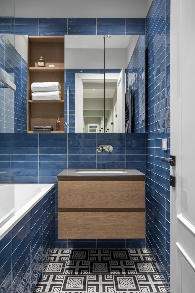 Idee per una stanza da bagno padronale design con ante lisce, ante in legno scuro, vasca ad alcova, vasca/doccia, piastrelle blu, lavabo sottopiano, pavimento multicolore e top grigio