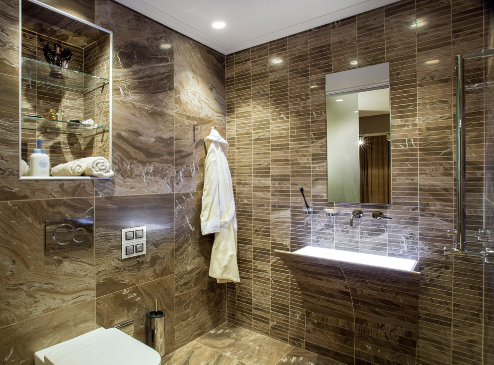 Foto på ett funkis badrum, med en toalettstol med separat cisternkåpa, brun kakel, stickkakel och ett väggmonterat handfat